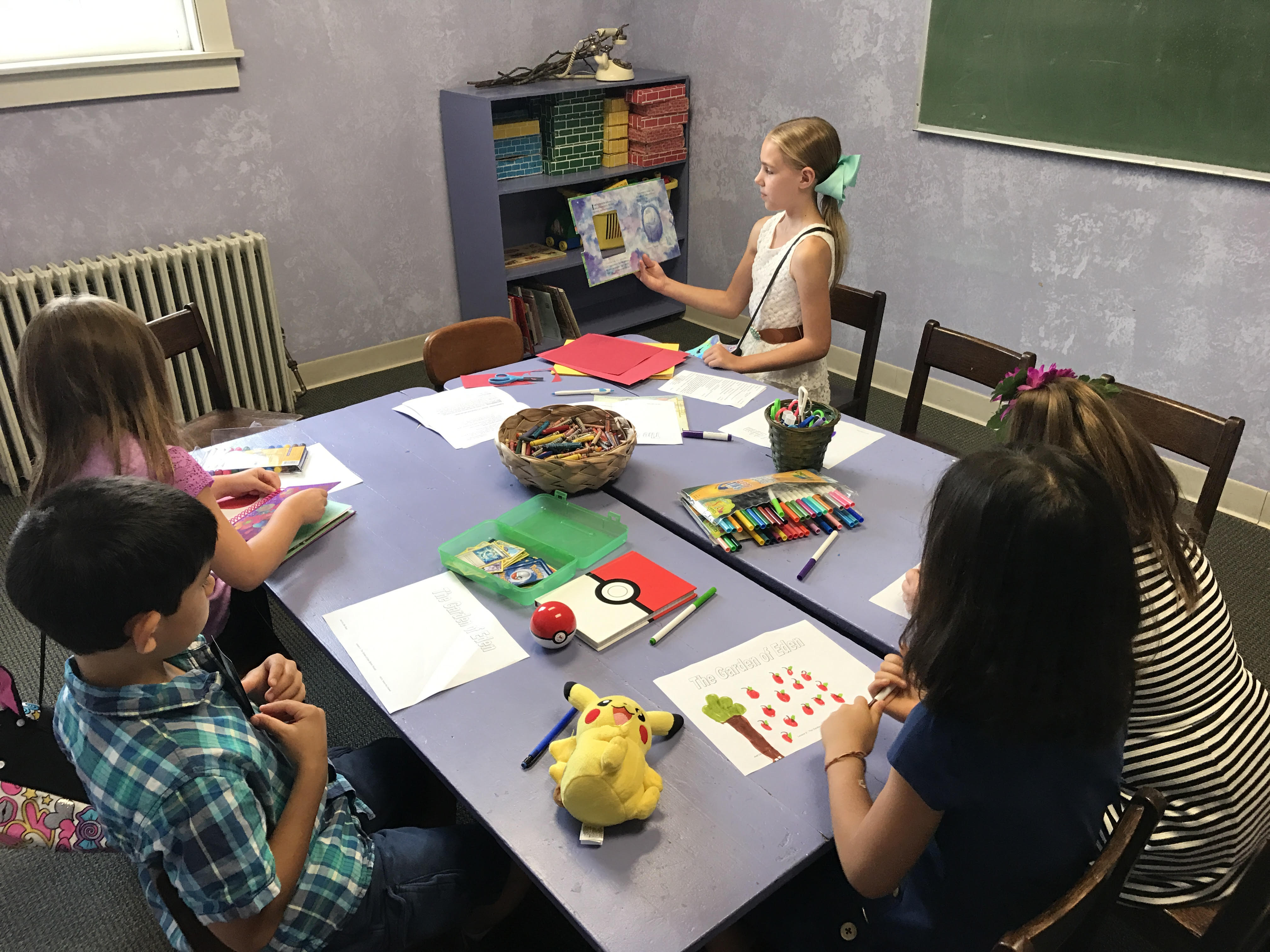 children sitting around a table doing arts and crafts